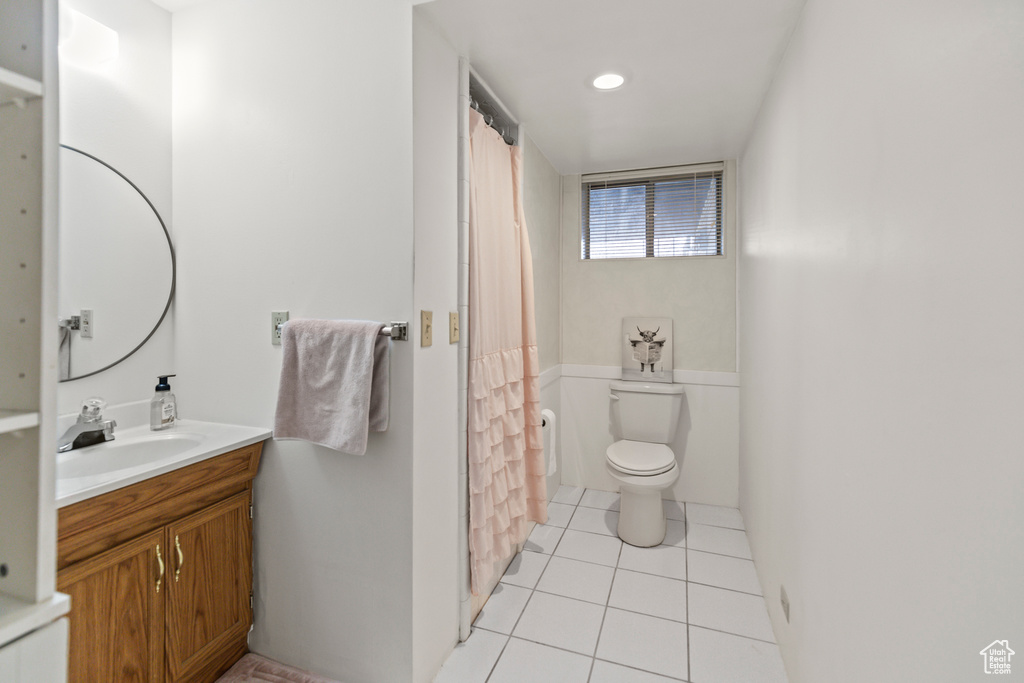 Bathroom featuring tile patterned flooring, vanity, and toilet