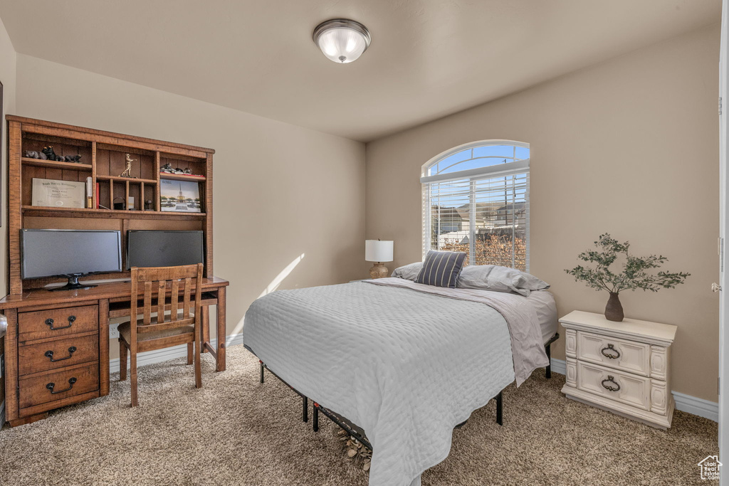 Bedroom featuring light colored carpet and baseboards