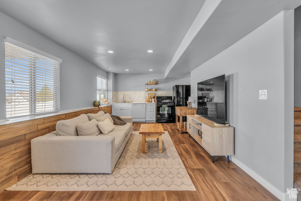 Living room with baseboards, wood finished floors, and recessed lighting