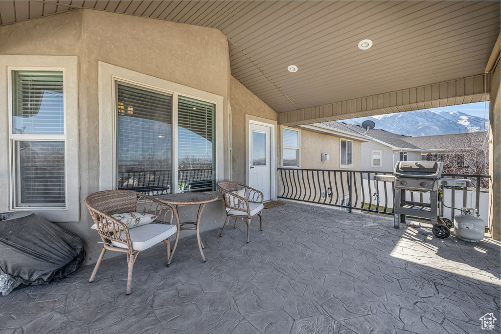 View of patio featuring area for grilling and a balcony