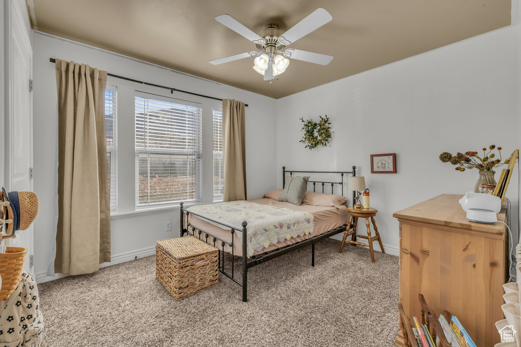 Bedroom with baseboards, a ceiling fan, and light colored carpet