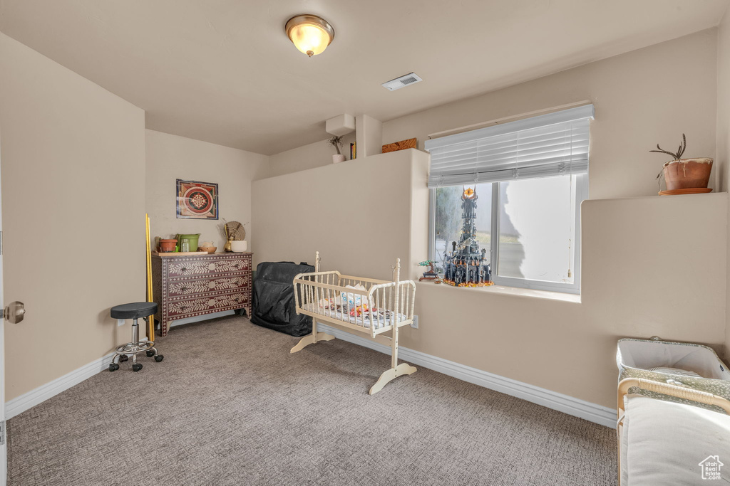 Carpeted bedroom featuring visible vents and baseboards