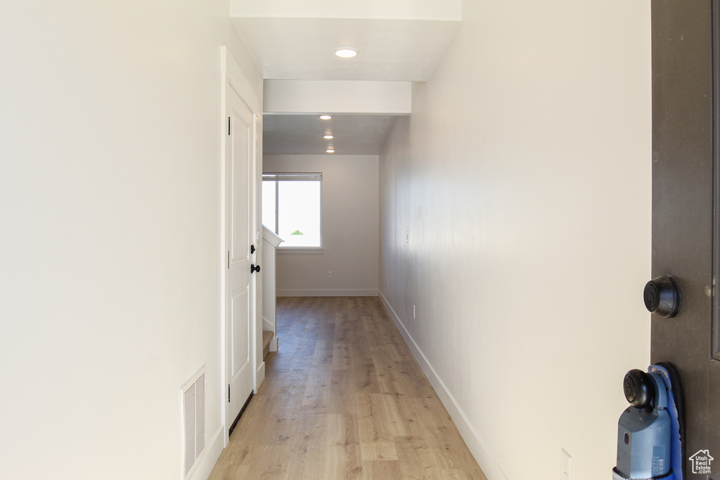 Hall with light wood-style floors, baseboards, visible vents, and recessed lighting
