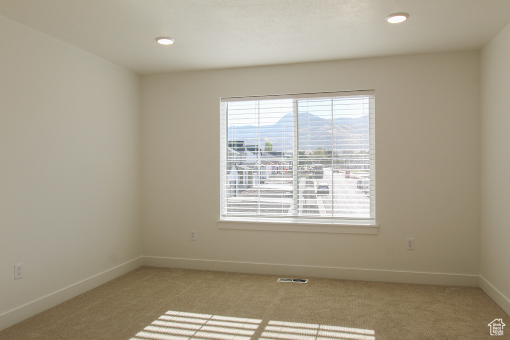 Unfurnished room with recessed lighting, baseboards, visible vents, and light colored carpet