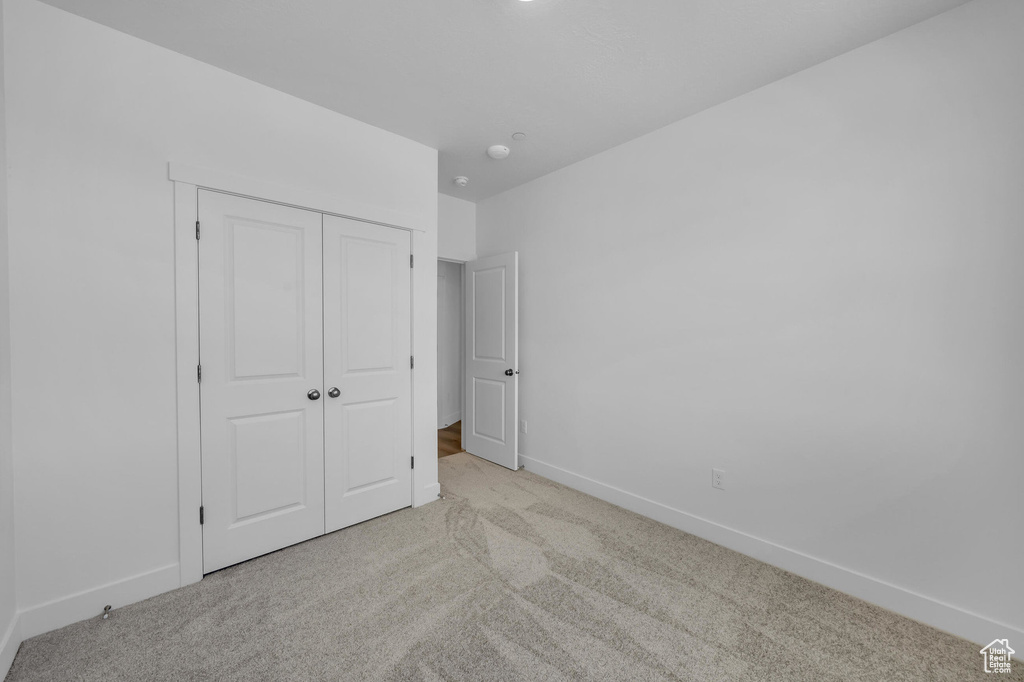 Unfurnished bedroom featuring a closet, carpet flooring, and baseboards