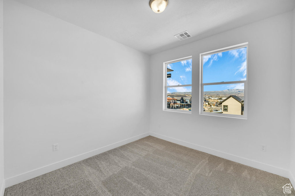Unfurnished room featuring baseboards, visible vents, and carpet flooring