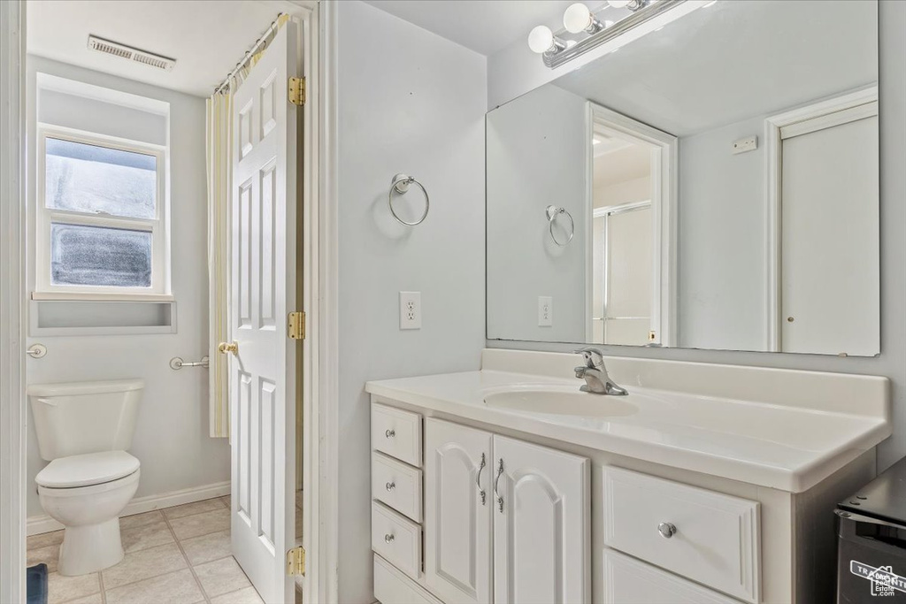 Bathroom featuring toilet, tile patterned flooring, visible vents, and vanity