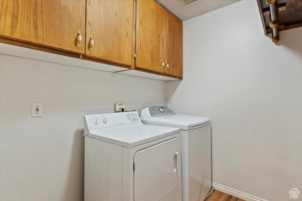 Laundry area with cabinet space, baseboards, and separate washer and dryer