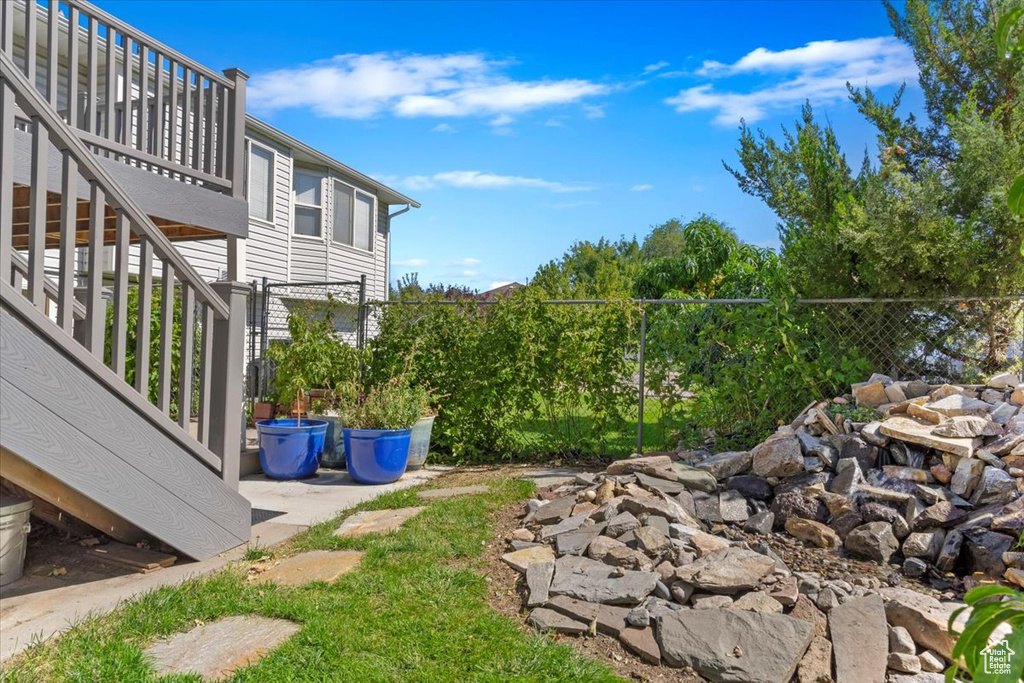 View of yard featuring fence and stairs