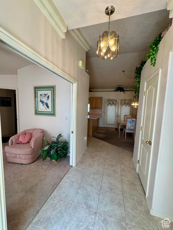Corridor with a chandelier, light carpet, a textured ceiling, and light tile patterned flooring