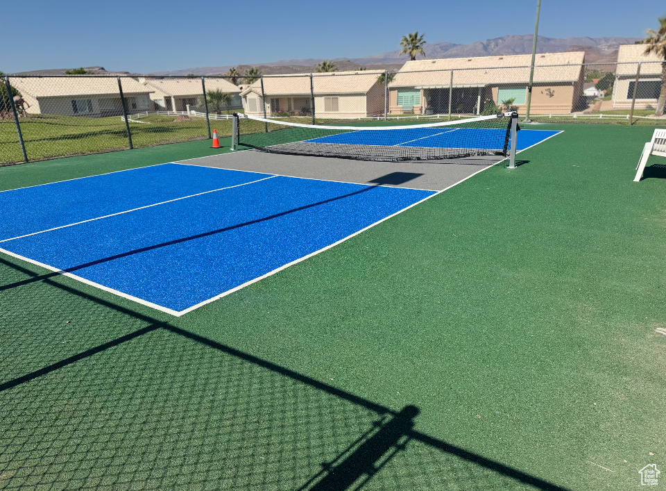 View of tennis court with a mountain view and a residential view