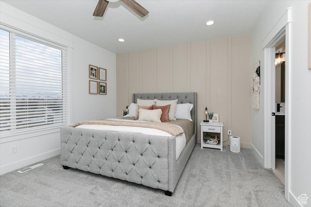 Bedroom featuring carpet, visible vents, a decorative wall, a ceiling fan, and baseboards