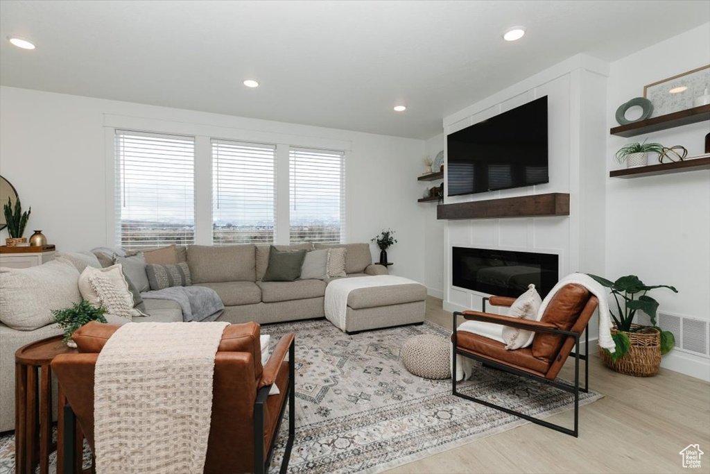 Living area with recessed lighting, a large fireplace, wood finished floors, visible vents, and baseboards