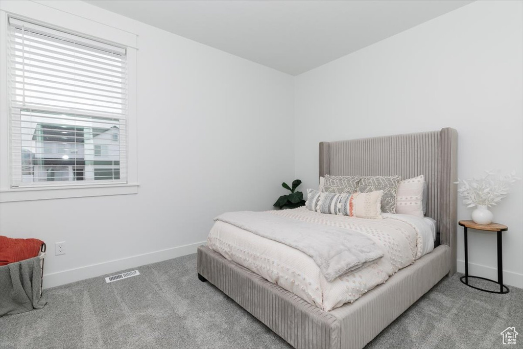 Carpeted bedroom featuring visible vents and baseboards