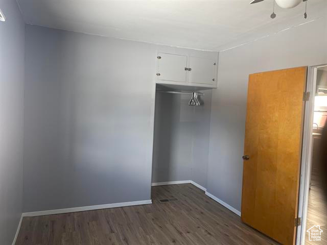 Spare room with ceiling fan, baseboards, and wood finished floors