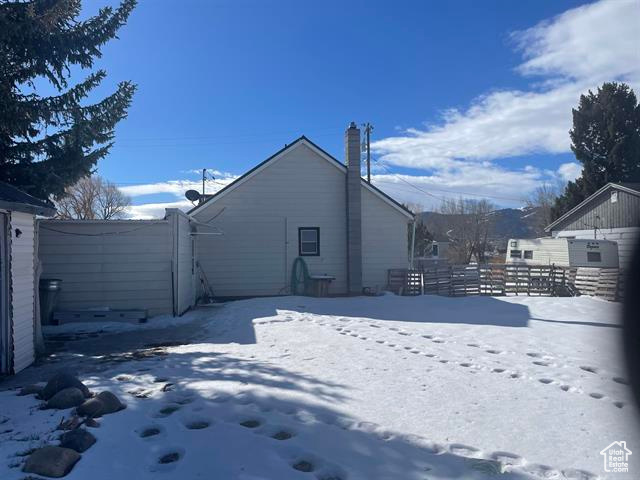 View of snowy exterior featuring fence