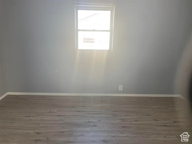 Spare room with baseboards and wood finished floors