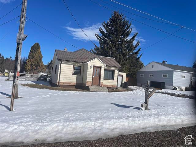 View of front of house featuring metal roof and fence