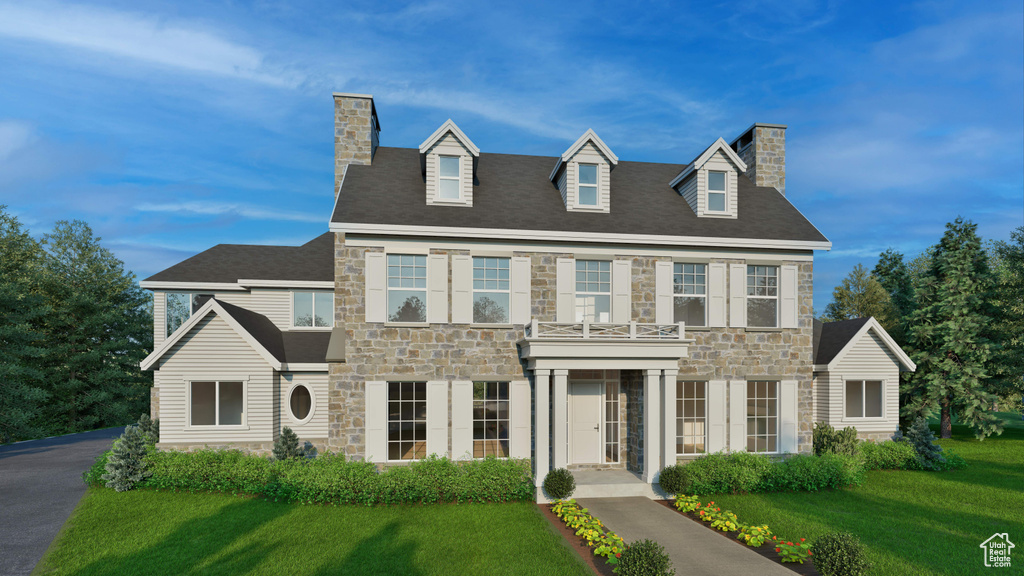 View of front of property featuring stone siding, a chimney, and a front yard