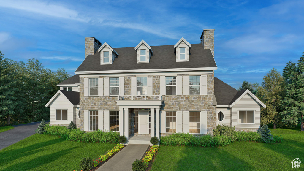 View of front of home featuring a chimney, stone siding, and a front yard