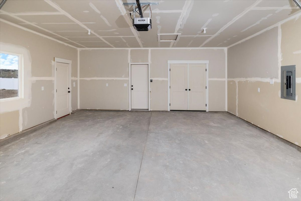 Garage featuring electric panel and a garage door opener