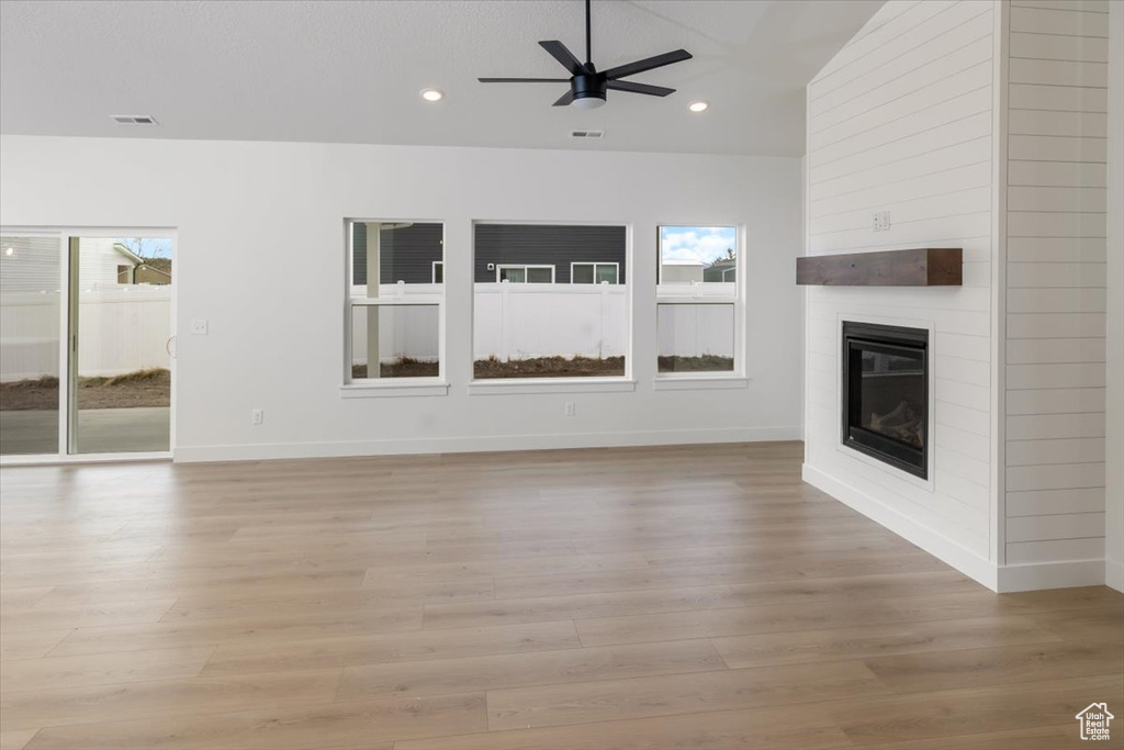 Unfurnished living room with light wood-type flooring, a fireplace, and recessed lighting