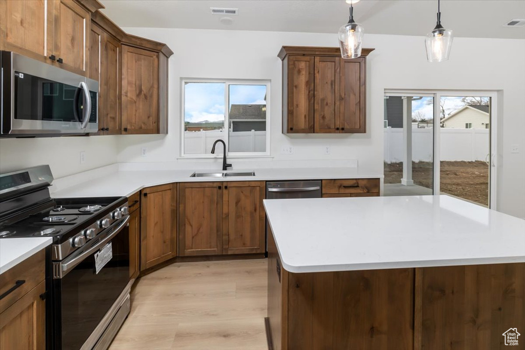 Kitchen with a wealth of natural light, appliances with stainless steel finishes, a sink, and visible vents