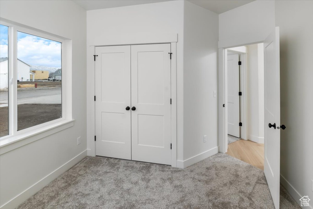 Unfurnished bedroom featuring a closet, baseboards, and carpet flooring