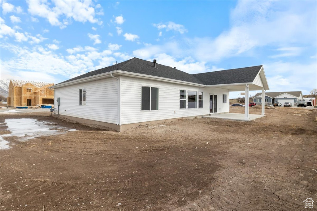 Back of house with a patio and a shingled roof