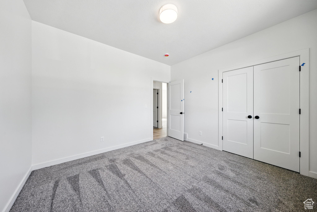 Unfurnished bedroom with carpet and a closet