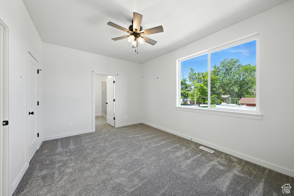 Unfurnished bedroom featuring carpet floors and a ceiling fan