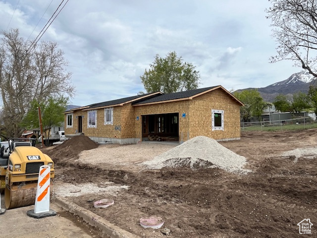 View of side of home featuring fence and a mountain view