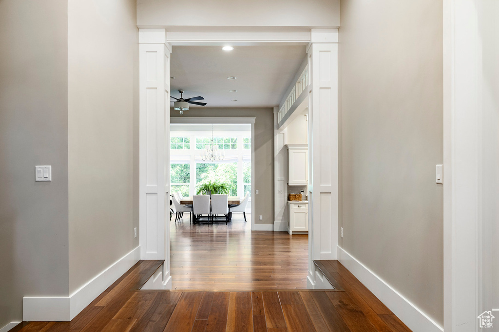 Hall with dark wood-type flooring, baseboards, and recessed lighting