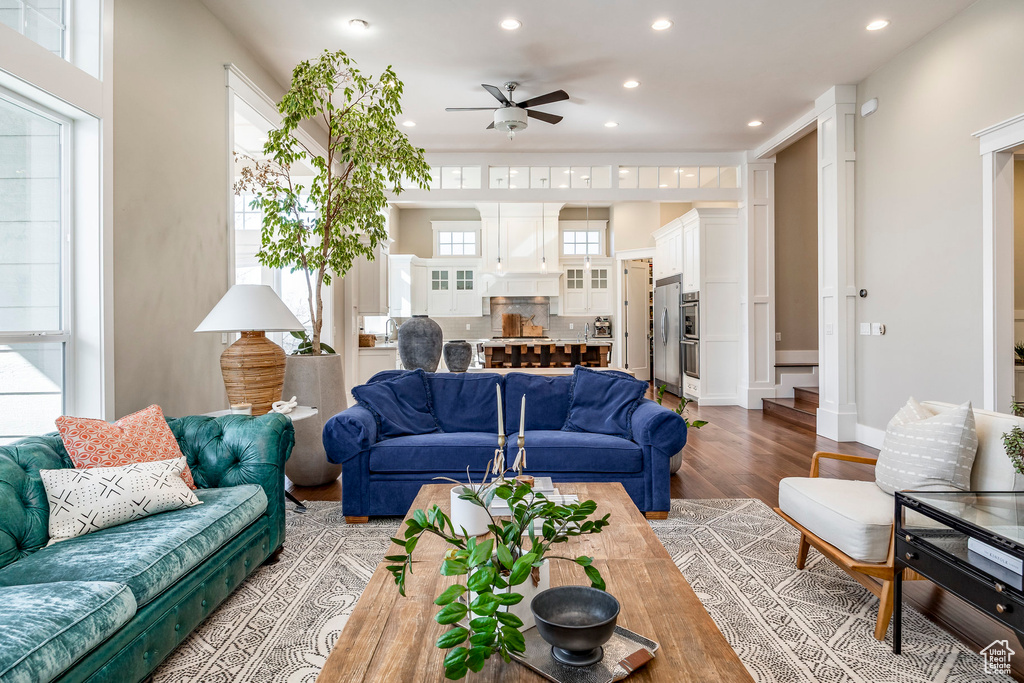 Living room with a ceiling fan, recessed lighting, light wood-style floors, and decorative columns