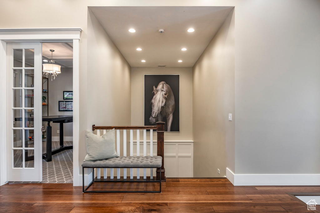 Hall featuring hardwood / wood-style flooring, recessed lighting, a chandelier, and baseboards
