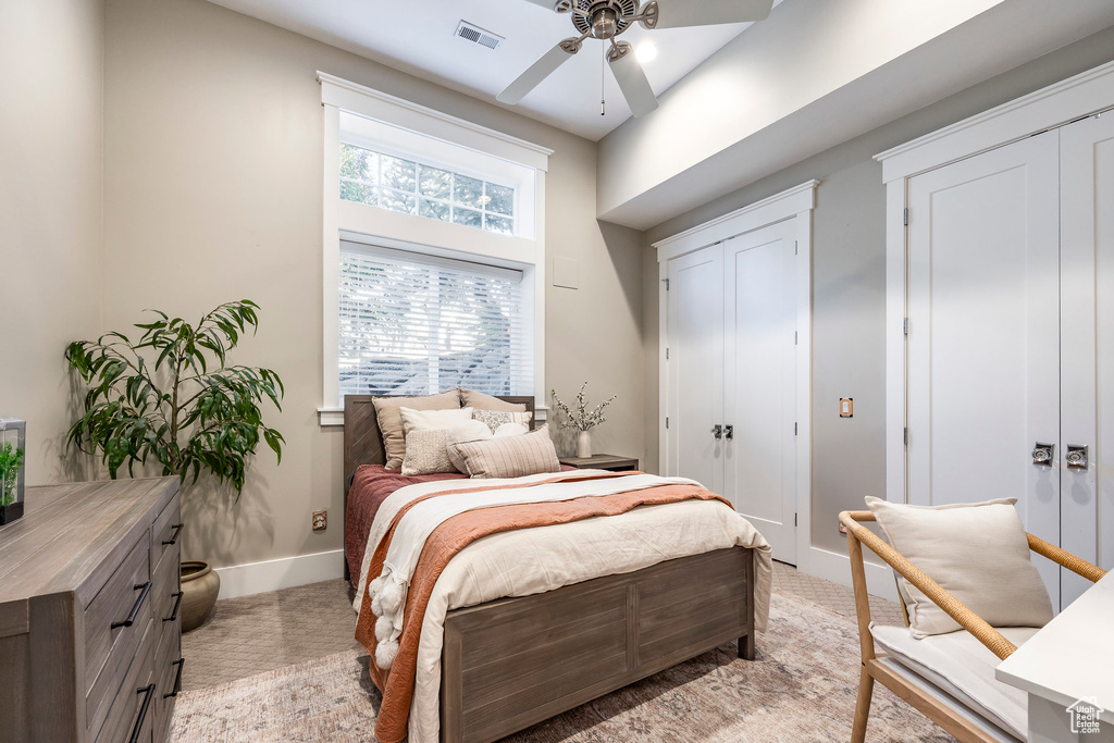 Bedroom featuring baseboards, multiple closets, and ceiling fan