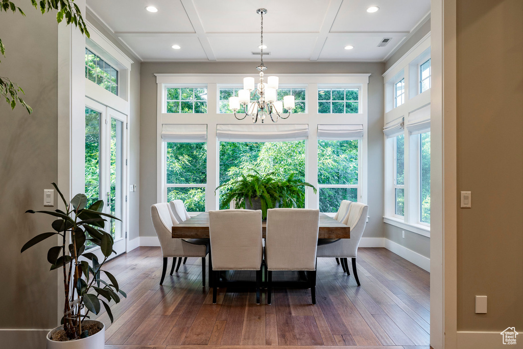 Dining area featuring a chandelier, coffered ceiling, hardwood / wood-style floors, baseboards, and recessed lighting