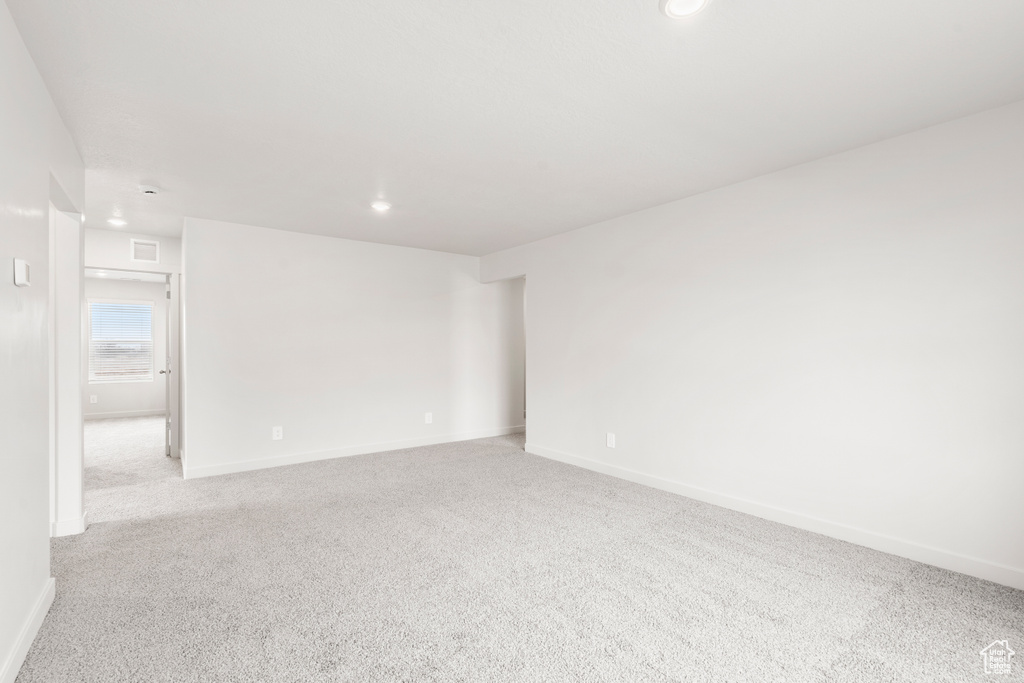 Spare room featuring recessed lighting, light carpet, baseboards, and visible vents