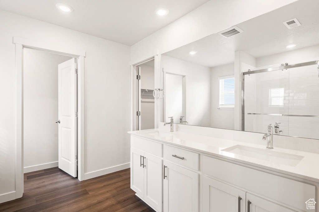 Bathroom with a stall shower, visible vents, and a sink