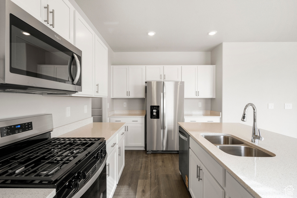 Kitchen with a sink, dark wood finished floors, stainless steel appliances, white cabinets, and recessed lighting