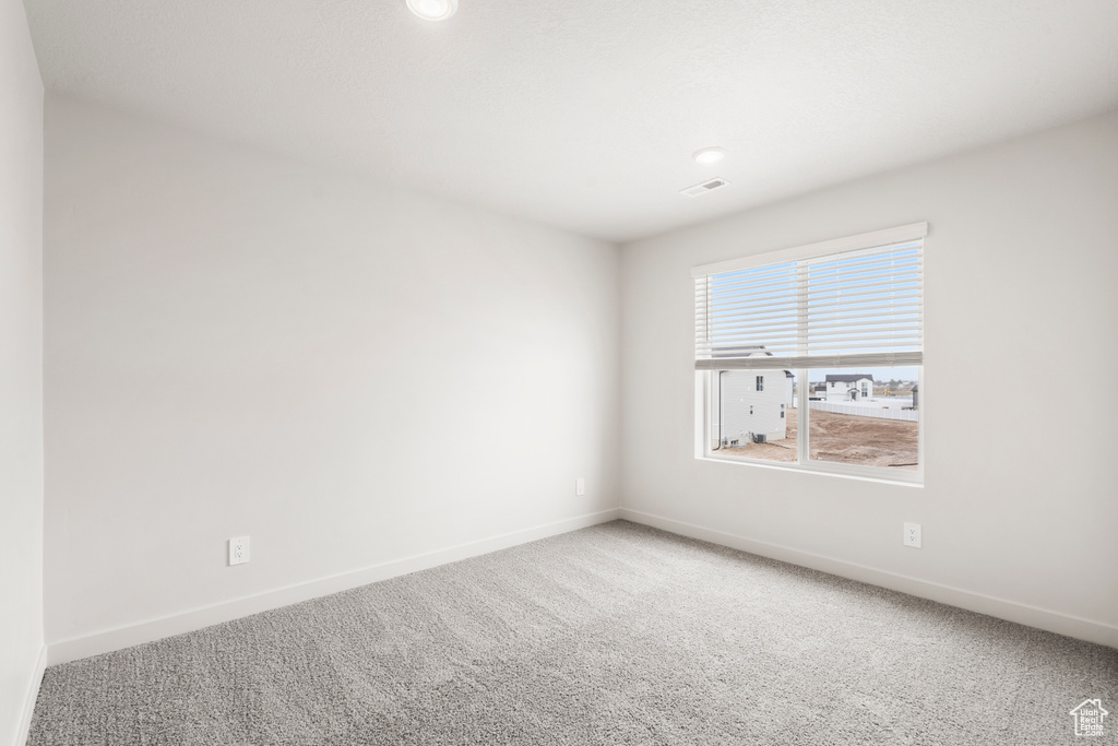 Empty room with baseboards, carpet flooring, and visible vents
