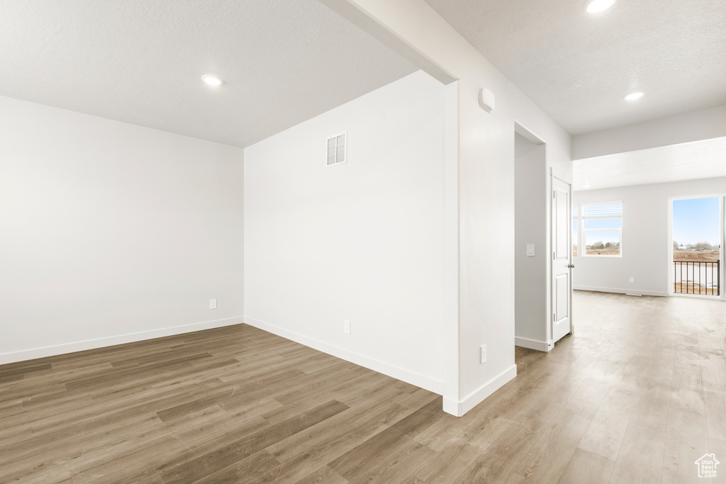 Spare room with recessed lighting, baseboards, light wood finished floors, and visible vents