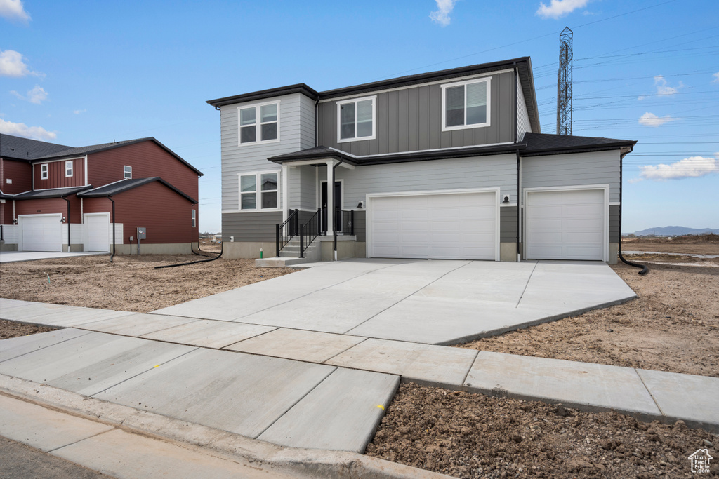 Traditional-style house with driveway, an attached garage, and board and batten siding