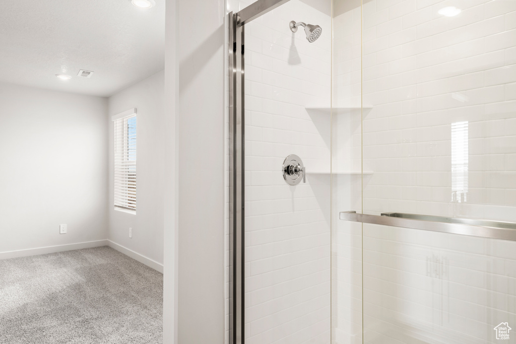 Bathroom with baseboards, visible vents, recessed lighting, and a shower stall