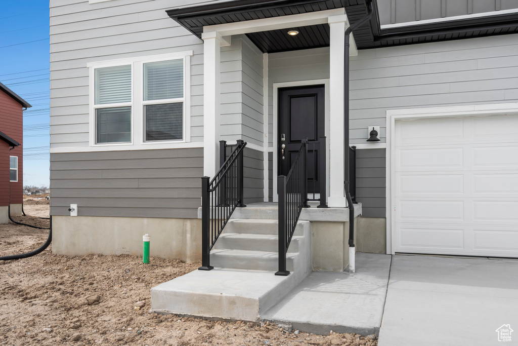 View of exterior entry featuring an attached garage