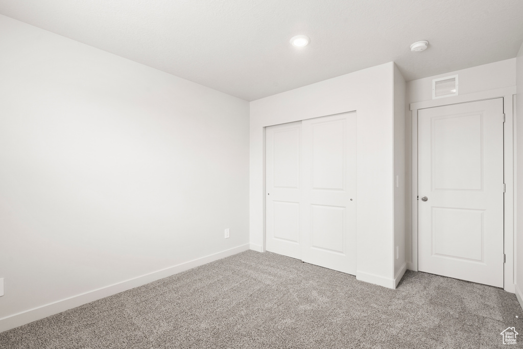 Unfurnished bedroom with baseboards, visible vents, a closet, and carpet flooring