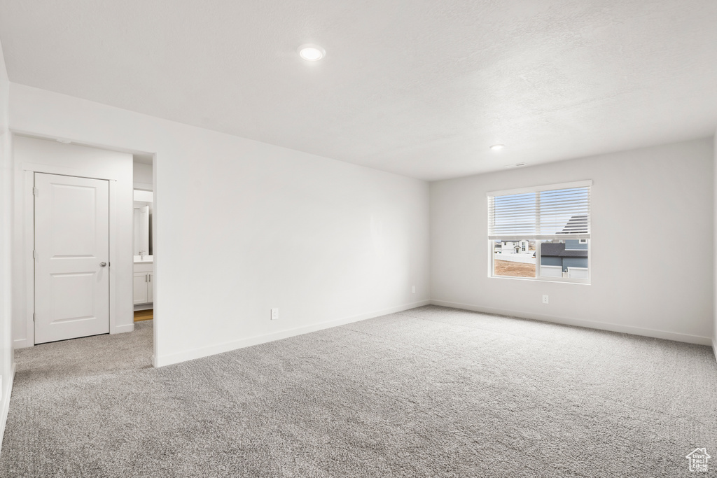Carpeted empty room featuring baseboards and recessed lighting