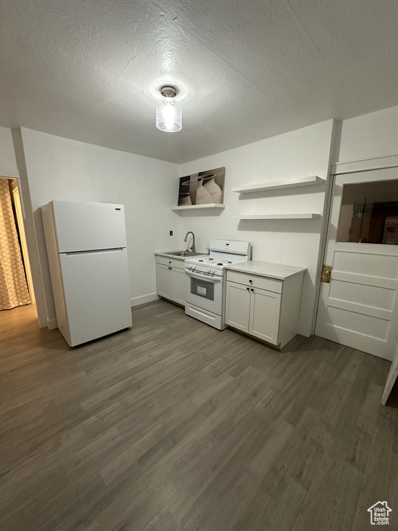 Kitchen with white appliances, dark wood-type flooring, a sink, white cabinets, and open shelves