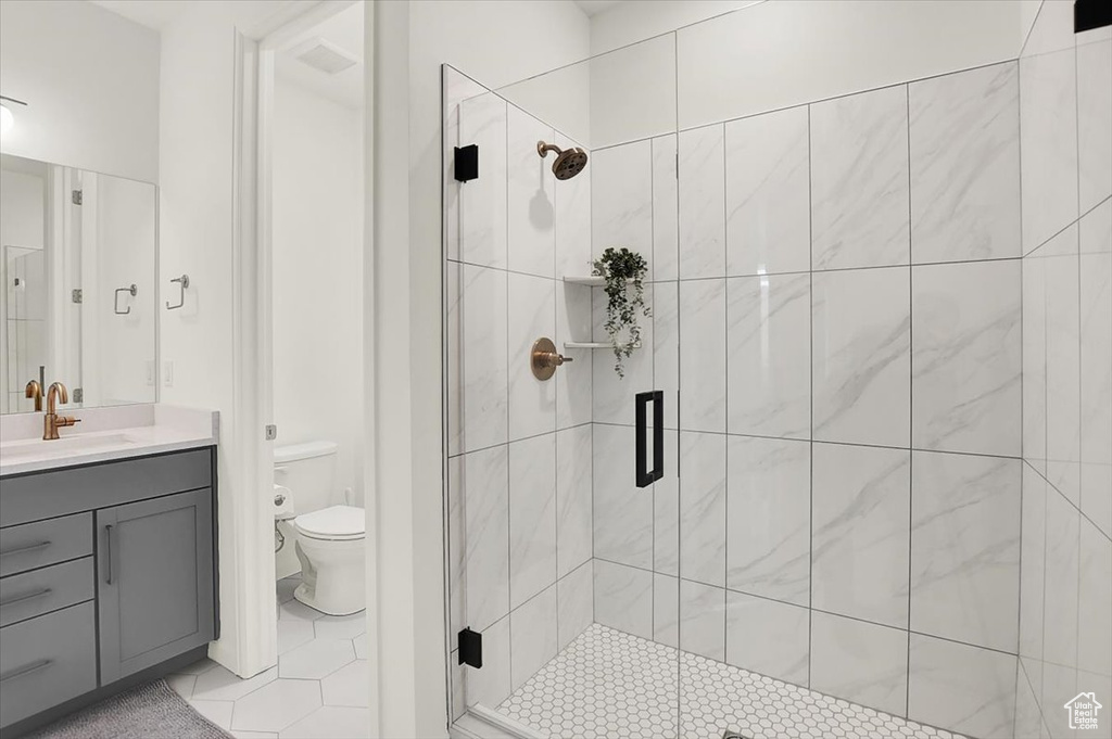 Bathroom with tile patterned flooring, a shower stall, toilet, and vanity