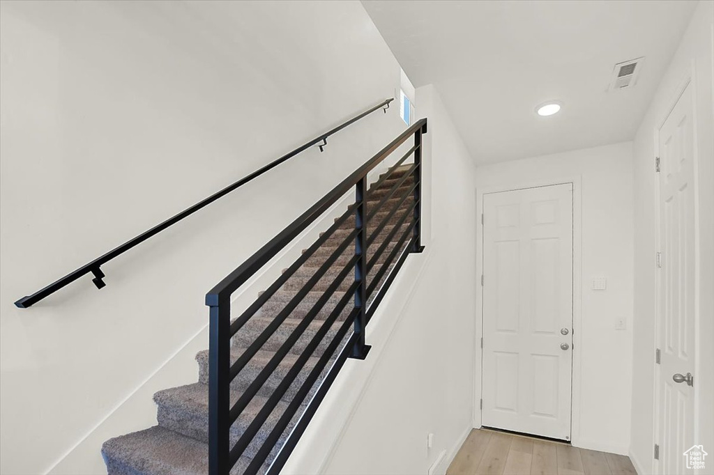 Stairway featuring visible vents and wood finished floors